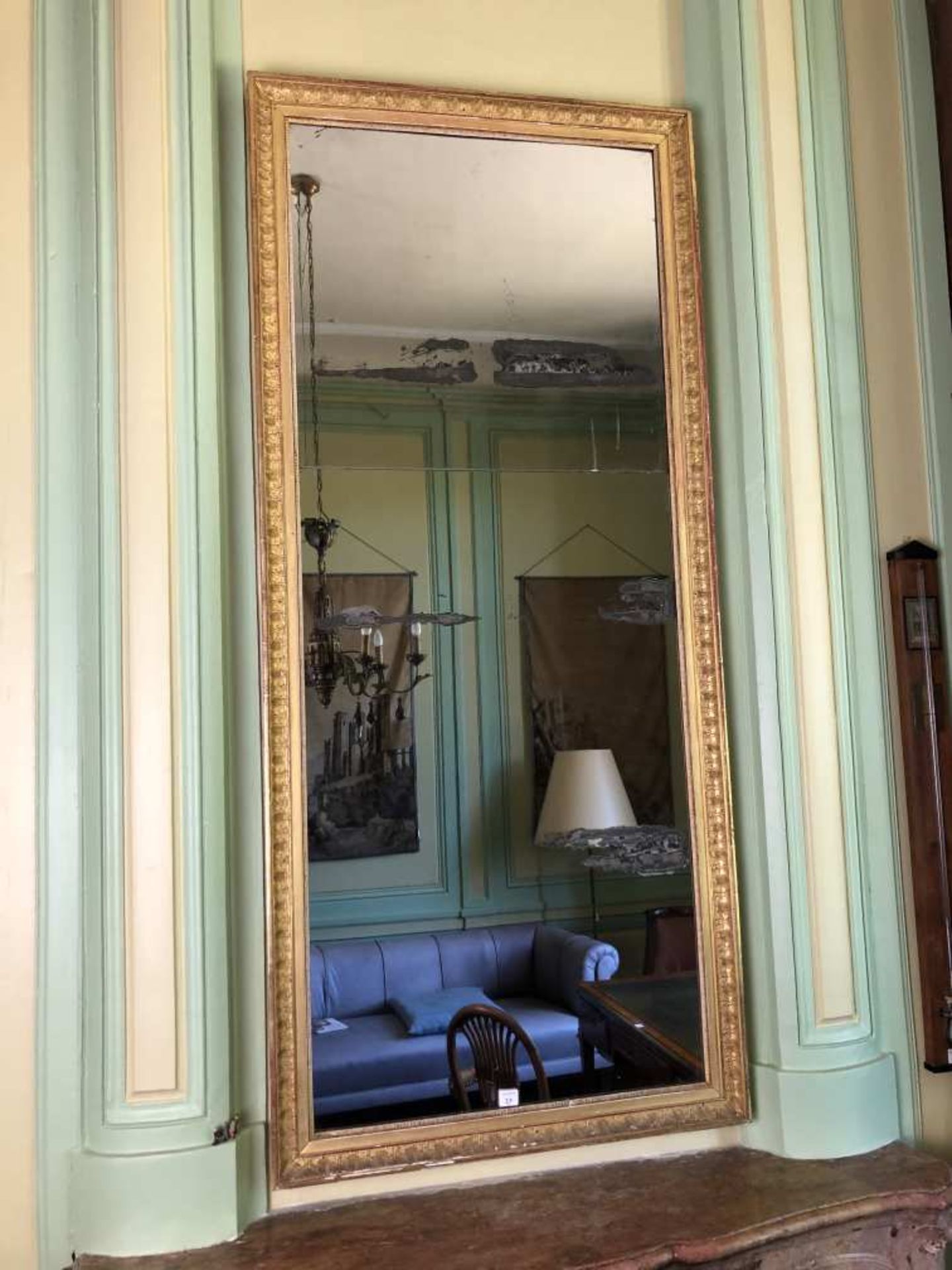 Miroir d'entre-deux en bois doré, le cadre à palmettes. 183 x 81 cm. Epoque Empire.