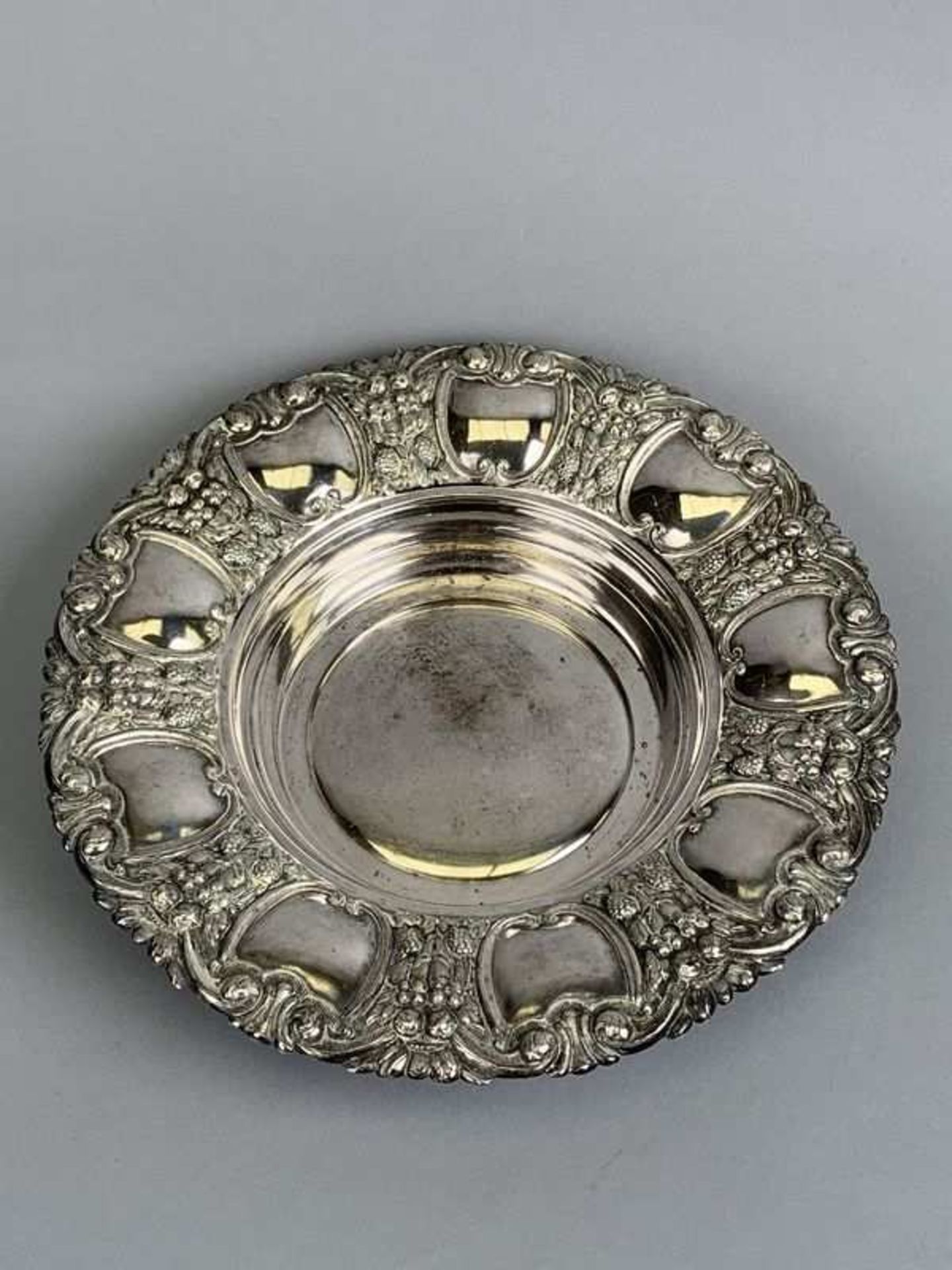 Plat en argent à riche décor végétal au repoussé. Poinçon "MTL P700". D. 30,3 cm. P. 386 g.