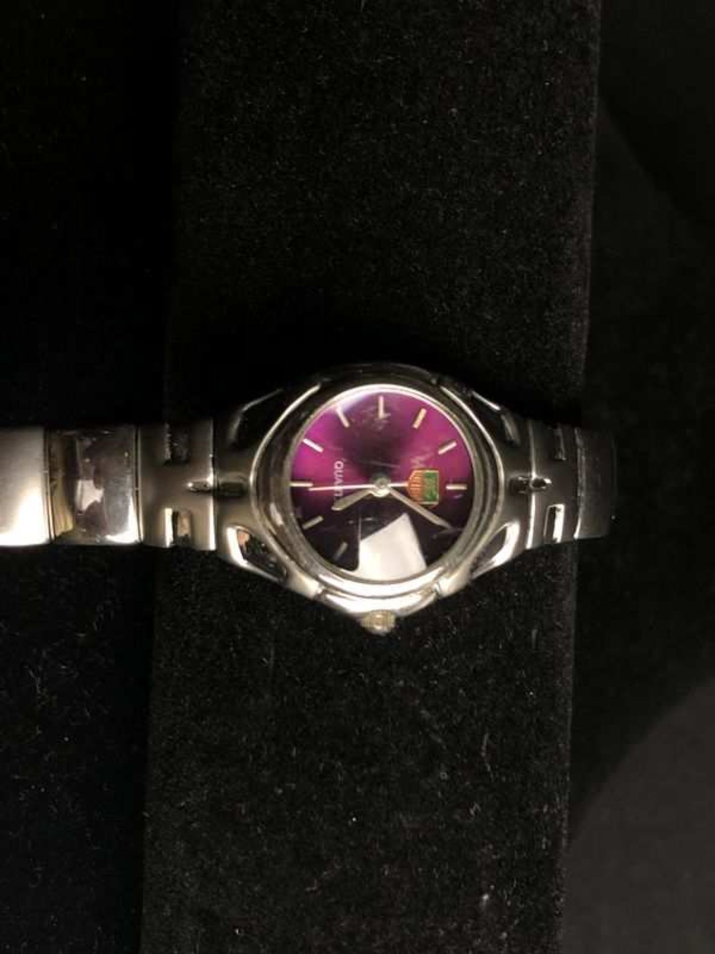 TAG HEUER. Montre de dame en acier, mouvement à quartz, fond mauve, verre loupé. Boîtier : 30 x 35