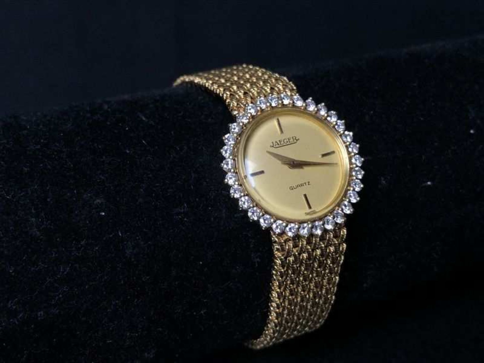 JAEGER. Bracelet-montre en or jaune, boîtier rond bordé de 32 petits diamants taille brillant,