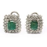 A pair of emerald and brilliant cut diamonds cluster earrings in an 18k. white gold setting