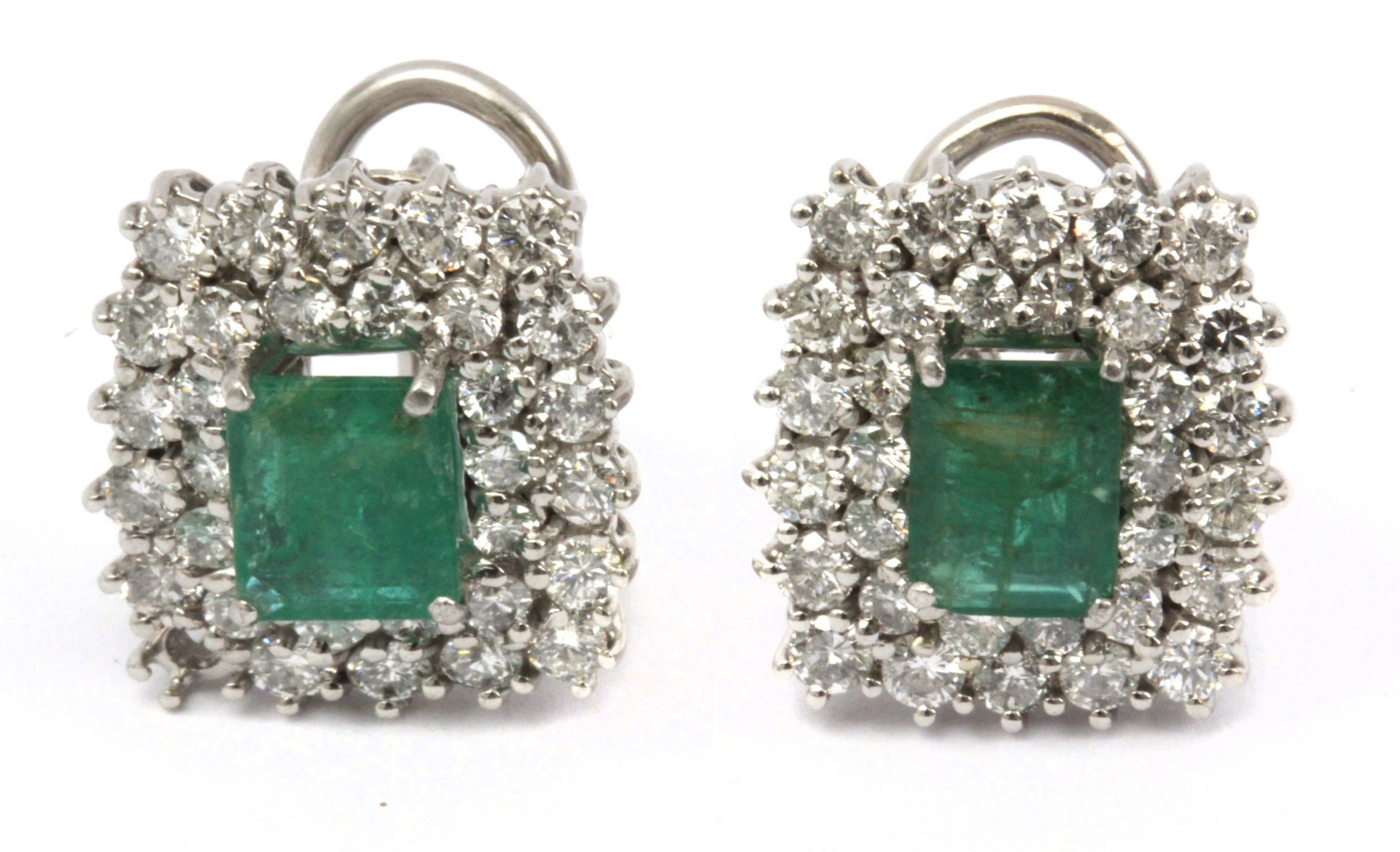 A pair of emerald and brilliant cut diamonds cluster earrings in an 18k. white gold setting