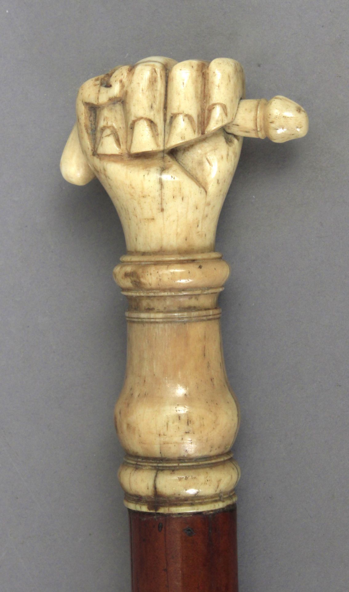 A 19th century cherry tree wood walking cane with a carved bone handle