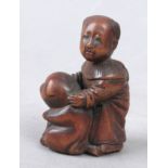 A 19th century Japanese netsuke in carved wood depicting Karako holding a puppy