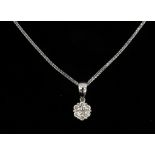 A diamond cluster pendant in an 18k white gold setting