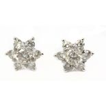 A pair of star shaped stud earrings in an 18k. white gold setting with brilliant cut diamonds