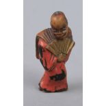 A 19th century Japanese netsuke in Negoro lacquer depicting an actor with an open fan