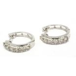 A pair of diamond hoop earrings with an 18k. white gold setting and brilliant cut diamonds