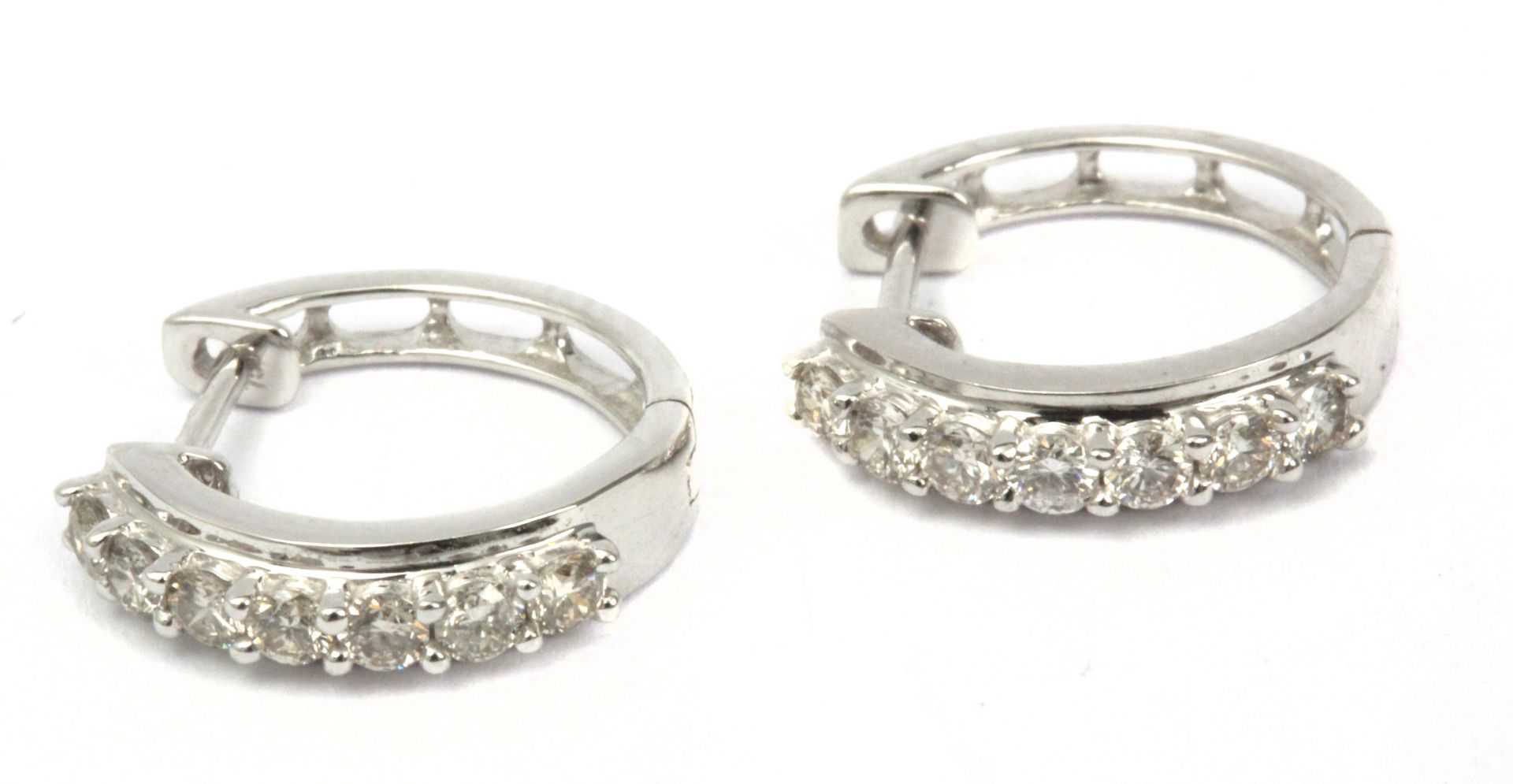 A pair of diamond hoop earrings with an 18k. white gold setting and brilliant cut diamonds