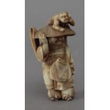 19th century Japanese school. A carved ivory netsuke depicting a Shoki carrying an Oni