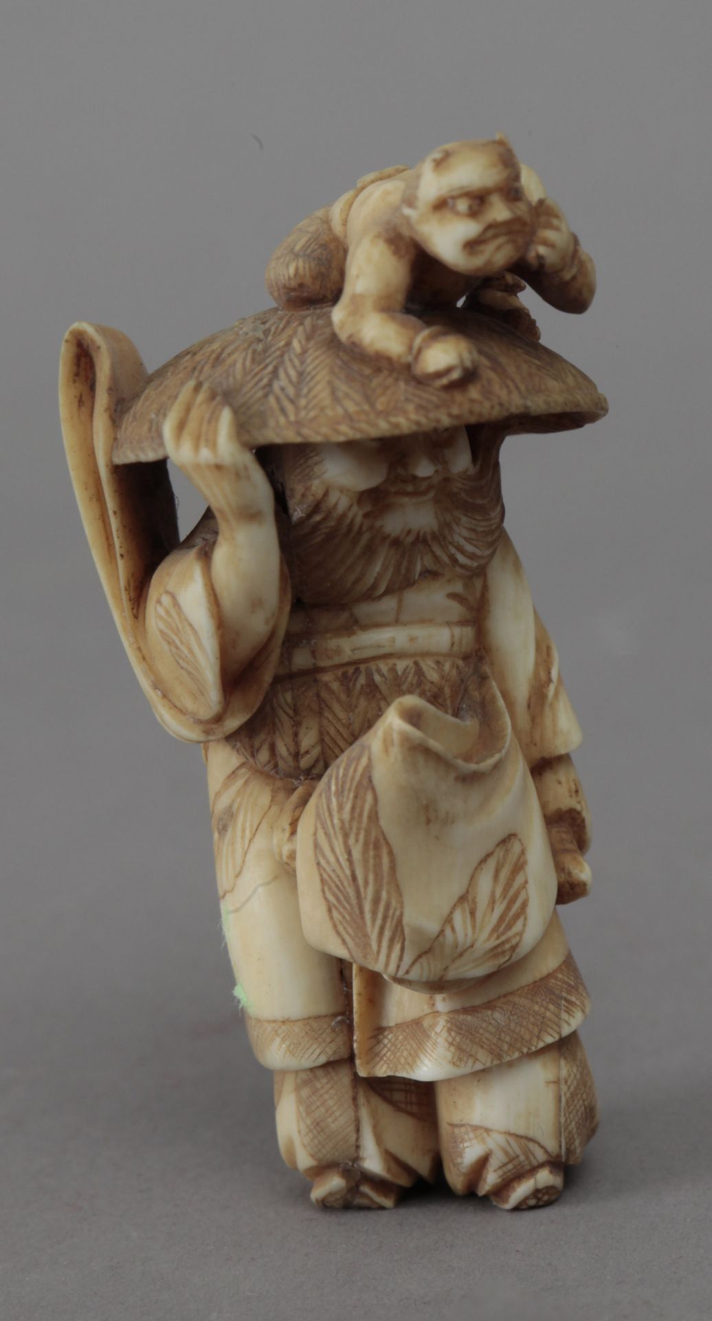 19th century Japanese school. A carved ivory netsuke depicting a Shoki carrying an Oni