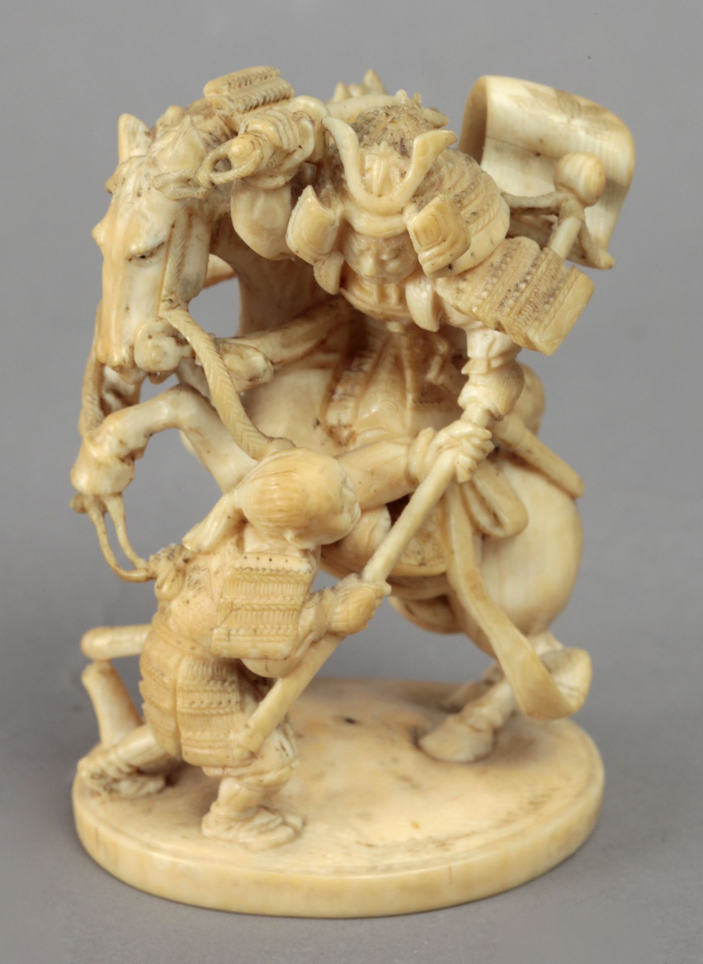 18th century Japanese school. A carved ivory okimono depicting a Samurai. Signed