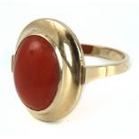 A ring circa 1950 with an 18k. yellow gold setting with an orangy coral oval cabochon