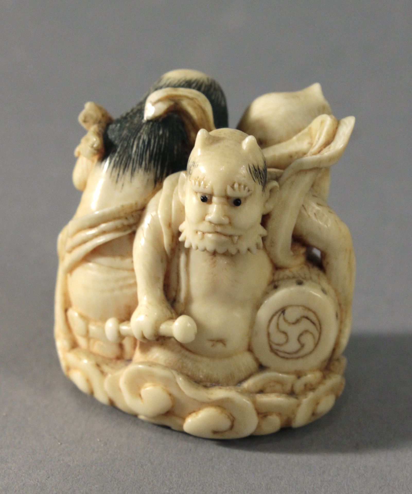 19th century Japanese school. A carved ivory netsuke depicting Oni playing a drum