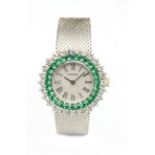 Omega. A ladies 18k. white gold wrist watch with diamonds and emeralds
