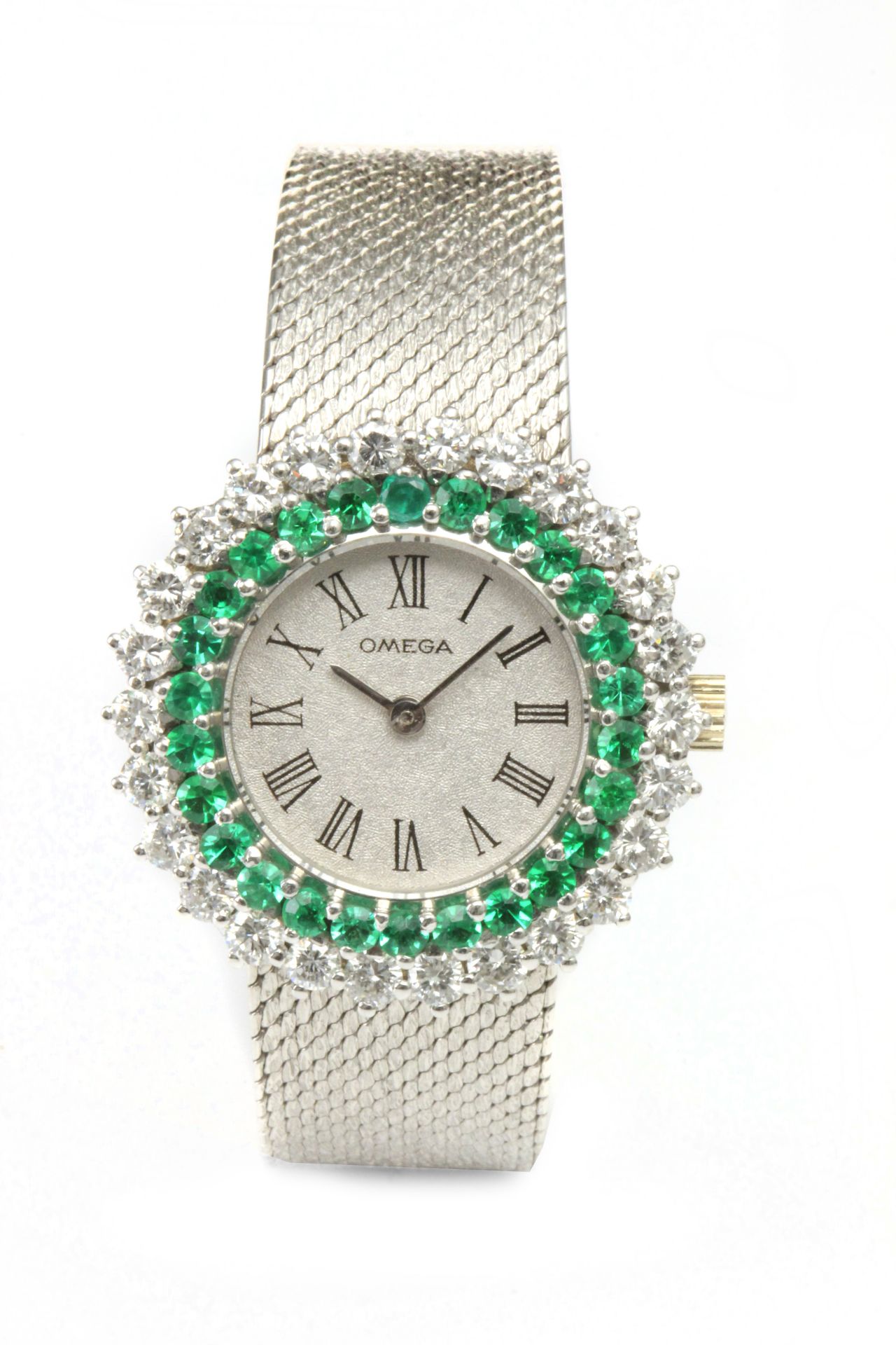 Omega. A ladies 18k. white gold wrist watch with diamonds and emeralds