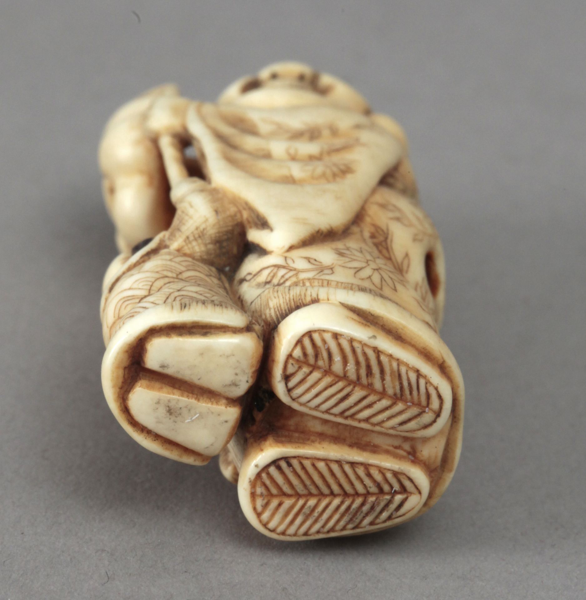 Early 19th century Japanese school. A carved ivory netsuke depicting a Hotei - Image 4 of 4