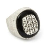 A diamond signet ring with an onyx plaque and 18k. white gold setting
