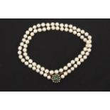 A cutured pearl necklace with an emerald and diamond brooch clasp