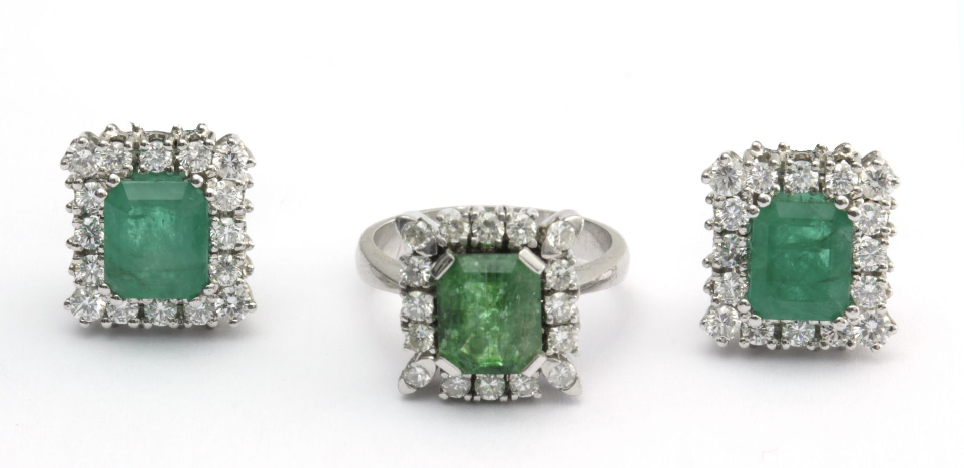 A set of emerald and brilliant cut diamond cluster ring and earrings with a platinum setting