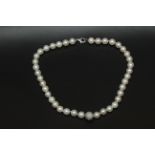 A cultured pearl necklace with an 18k. white gold and diamond pave central bead