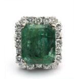 An emerald and diamond cluster ring circa 1970 with a platinum setting