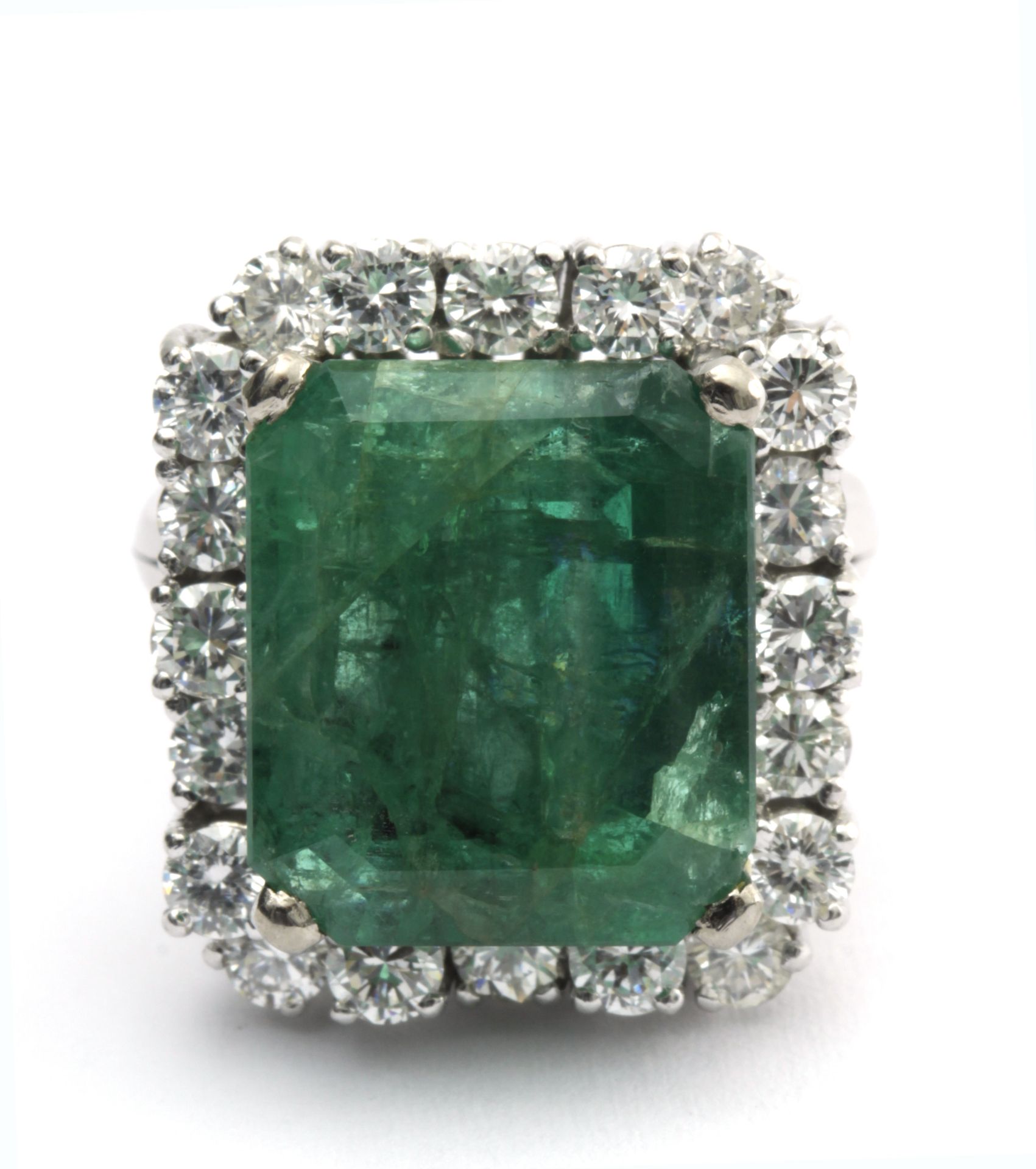 An emerald and diamond cluster ring circa 1970 with a platinum setting