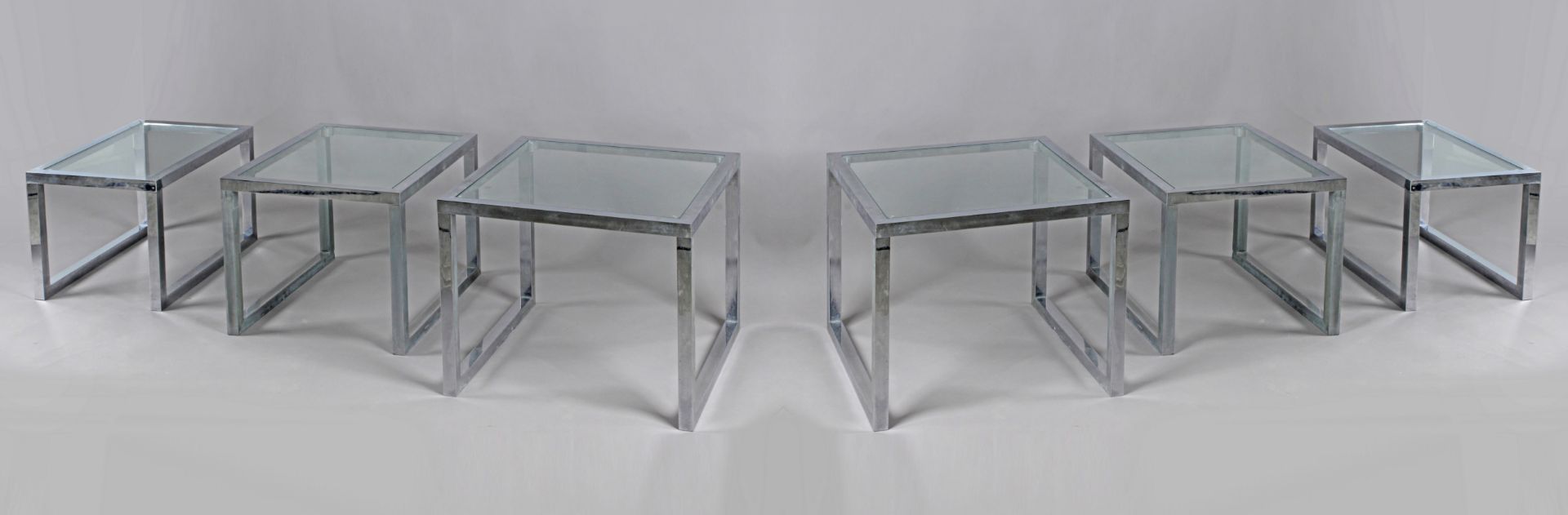 A set of six nest tables. With a chroming steel structure and glass tops