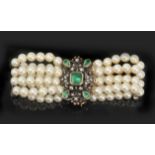 A four strand cultured pearl bracelet with an emerald and diamonds brooch clasp