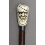 A 19th century English walking cane in carved chestnut wood, ivory and silver