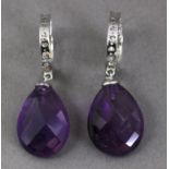 A pair of diamond hoop earrings with amethyst pendants