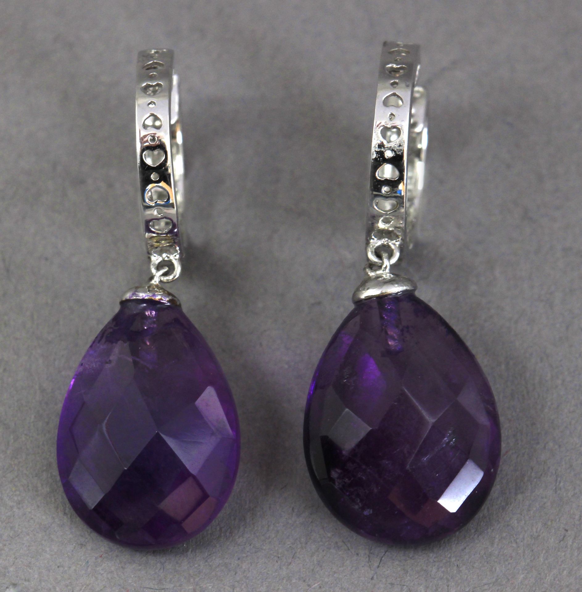 A pair of diamond hoop earrings with amethyst pendants