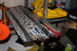 Assorted Surveying Measuring Staffs, as set out on one tier of rack