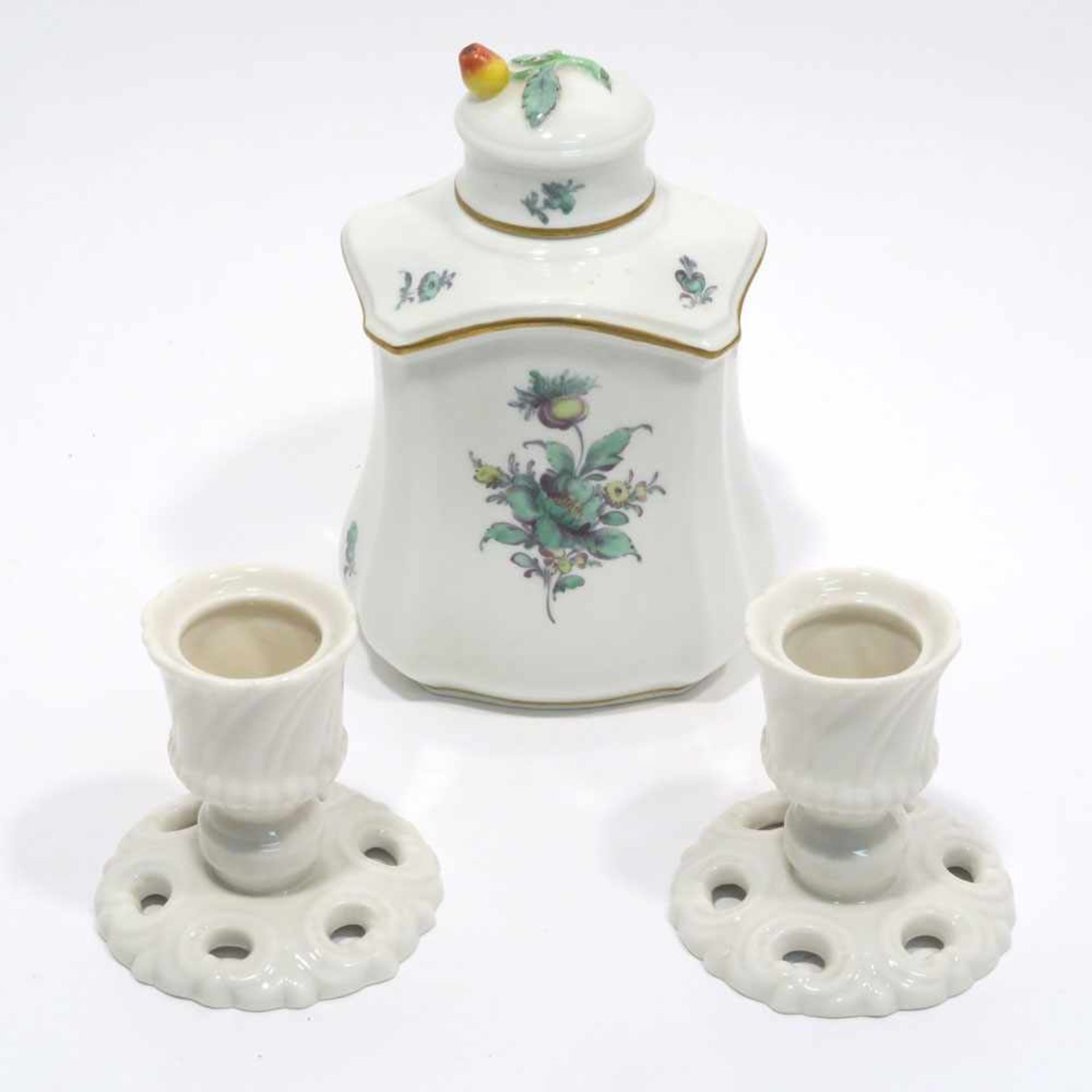 Teedose und zwei KerzenleuchterNymphenburg. Teedose in geschwungener Rechteckform mit grünem