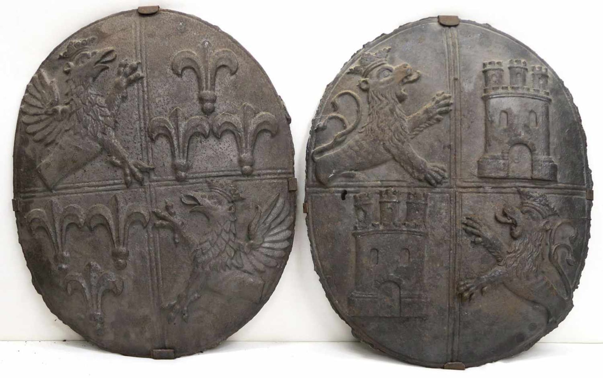 Ein Paar WappenschildeEisen, reliefiert. Jeweils ovale Form, geviertelt mit einem Greif links oben