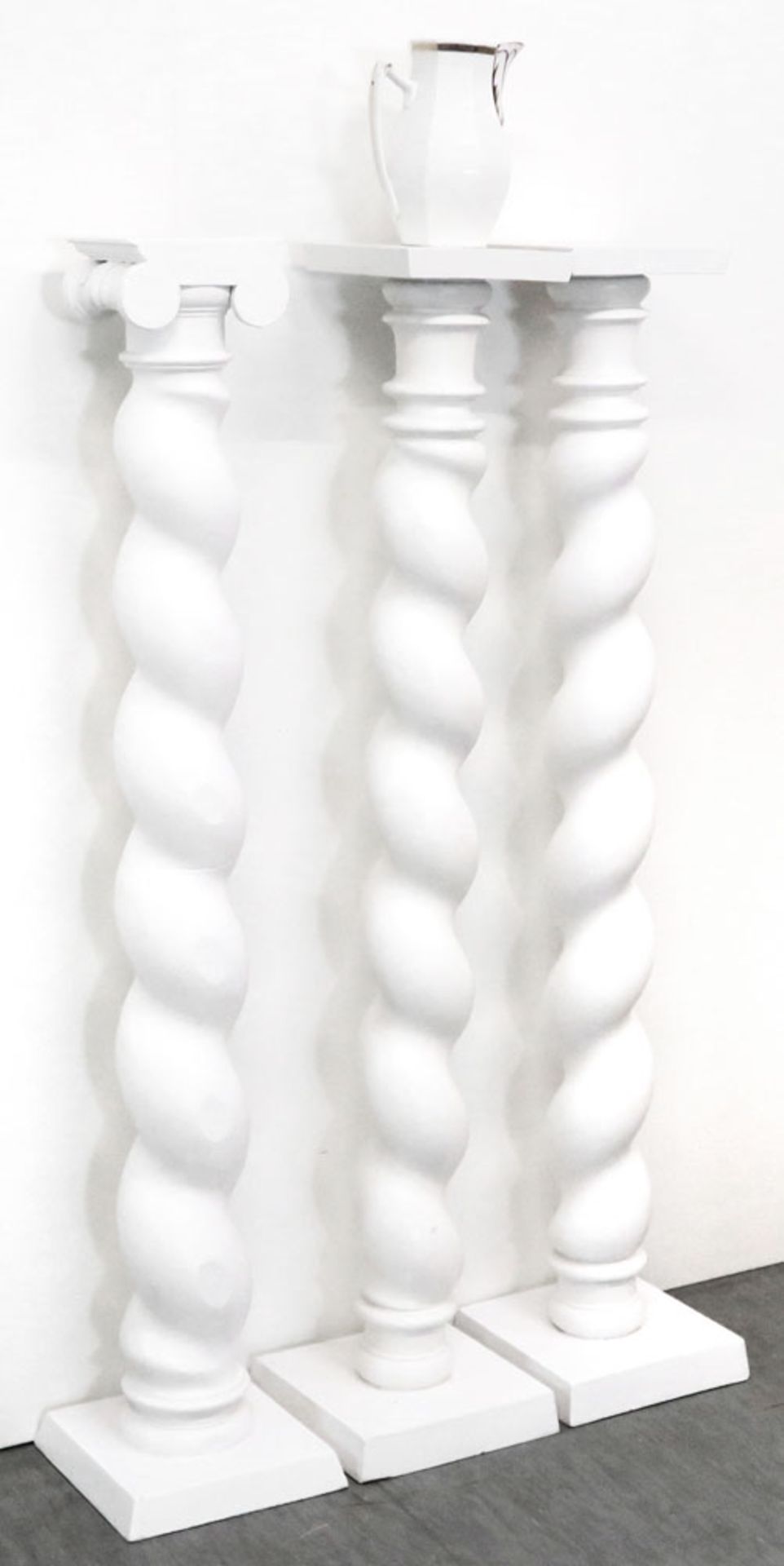 Drei SäulenHolz, weiß gefasst. Auf quadratischer Plinthe gedrehter Schaft mit verschiedenen