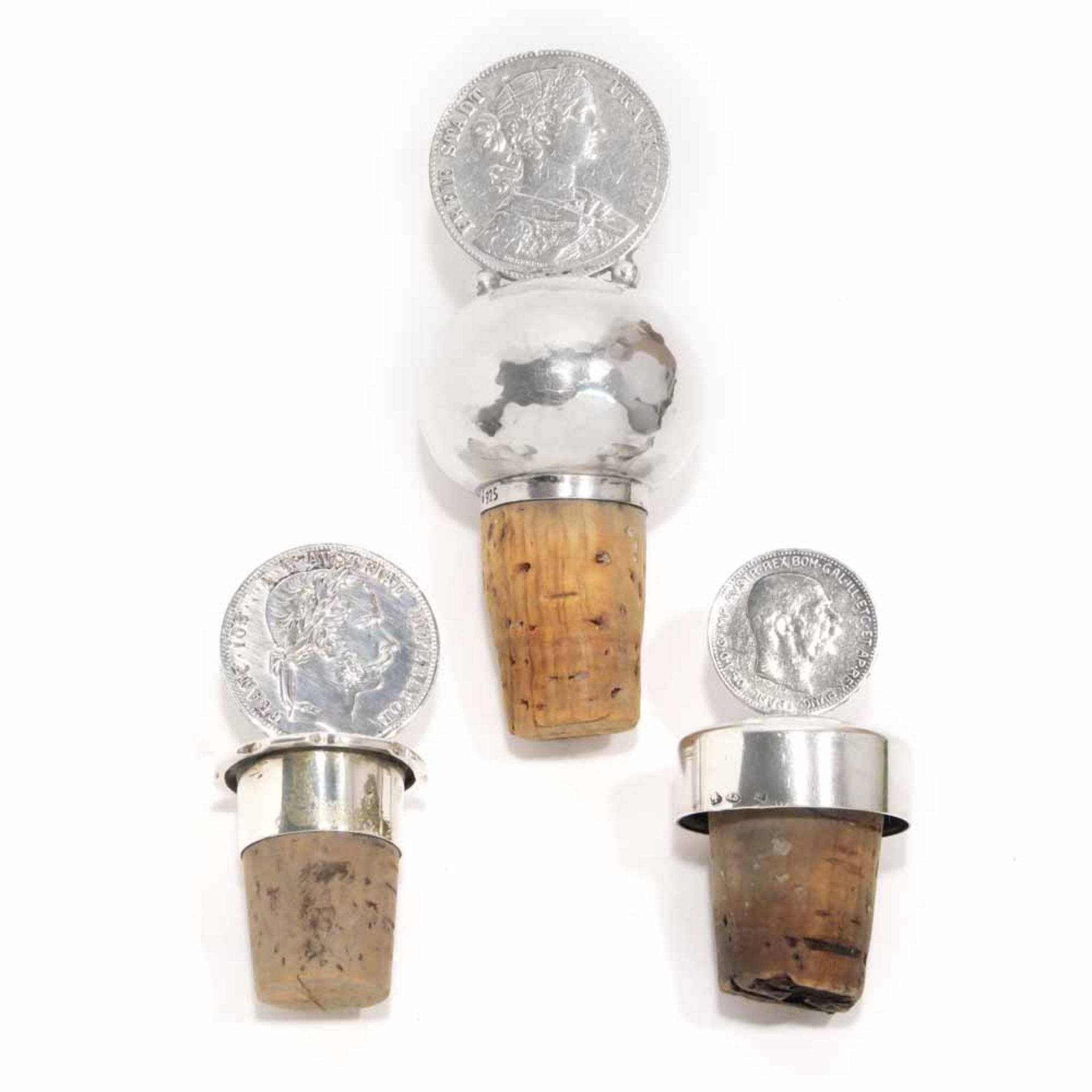 Drei Flaschenkorken mit Münzen