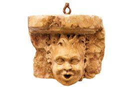 Kleine BrunnenmaskeItalien, 20. Jh.In Form einer Konsole mit Puttenkopf. Orangefarbener Marmor. 24 x