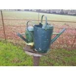 A pair of green Metal Watering Cans.