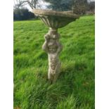 A stone Bird Bath with a sculpture of a child.