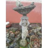 A Stone Birdbath with a sculpture of a child.