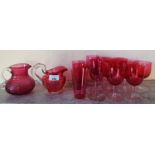 A 19th Century Cranberry Glass Jug and one other along with a good quantity of cranberry glasses.