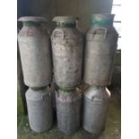 A quantity of Aluminium Milk Churns with lids.