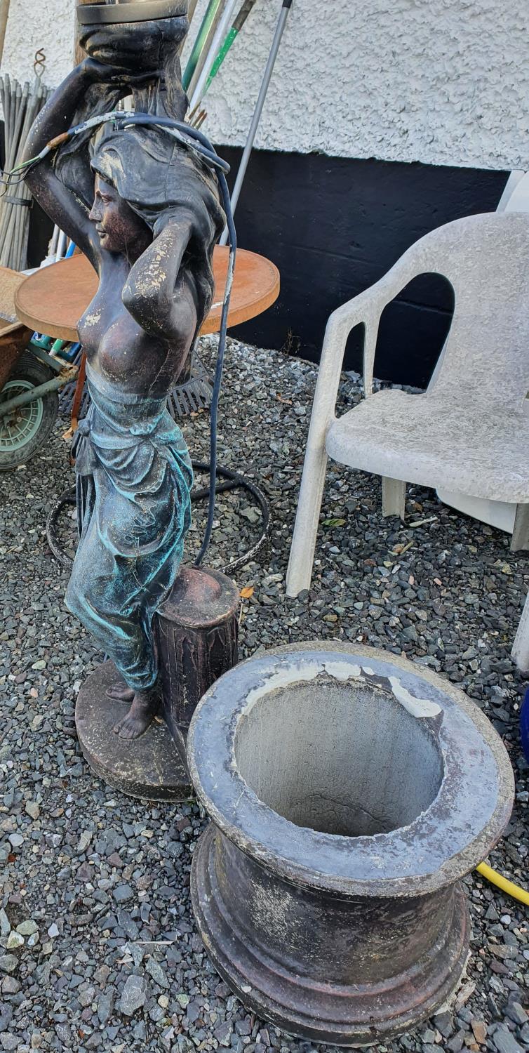 A large Stone Water Feature of a semi naked woman.