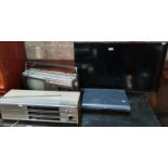 A Samsung Television, a vintage Sharp TV/Tape deck, vintage radio and sky box.