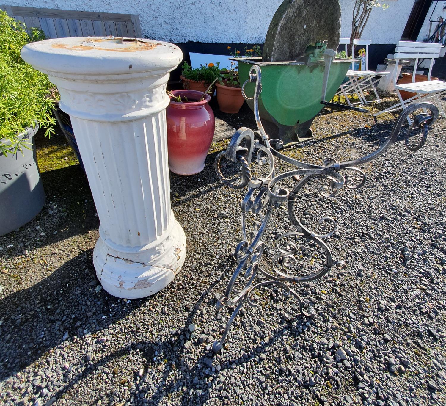 A Metal Garden Stand along with a columned plaster Pillar.