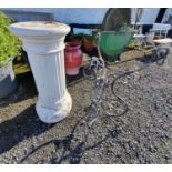 A Metal Garden Stand along with a columned plaster Pillar.