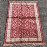 A red ground Cashmere Rug with a floral pattern. 230cms x 156cms.
