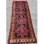 A large Persian Heriz Runner with medallion design. 345cms x 125cms.
