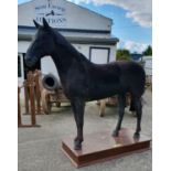 A Life size Horse made from Fibreglass on a plinth base.